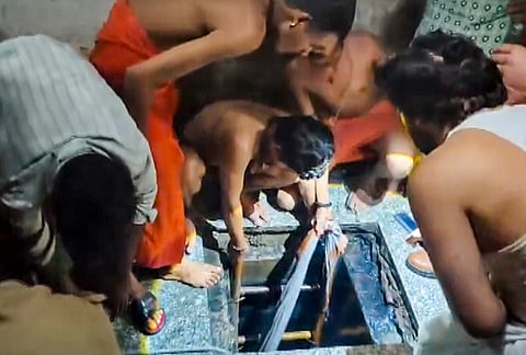People gather and attempt rescue operations after four students allegedly died due to toxic gas exposure while cleaning a submersible water tank at a local school, in Mathura district, Uttar Pradesh. Authorities have ordered a probe into the incident. 
