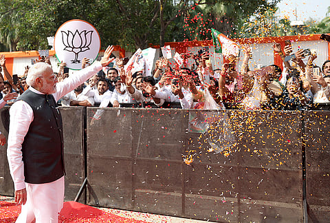 Prime Minister Narendra Modi waves to supporters during the Viksit Bharat Sankalp Sabha at the Indira Gandhi Indoor Stadium, in New Delhi. The event marks PM Modi completing 25 years as head of government in public office, tracing back to October 7, 2001, when he was sworn in as the Chief Minister of Gujarat. 
