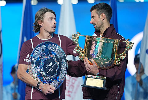 Novak Djokovic, of Serbia,right, holding winner's trophy, talks with Alex De Minaur, of Australia after winning the men's singles final at the China Open tennis tournament in Beijing, Tuesday, Oct. 6, 2026.