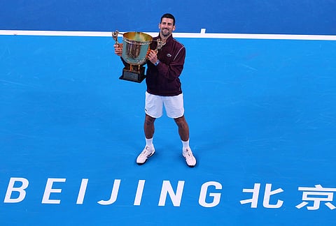 Novak Djokovic, of Serbia, poses with the trophy after winning the men's singles final match against Alex De Minaur, of Australia at the China Open tennis tournament in Beijing, Tuesday, Oct. 6, 2026. 
