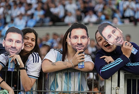 Fans hold masks depicting Lionel Messi before his final match for Argentina, a soccer friendly against Benin, in Buenos Aires, Argentina, Tuesday, Oct.6, 2026. 