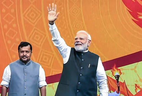 Prime Minister Narendra Modi waves to supporters upon his arrival to address the Viksit Bharat Sankalp Sabha, in New Delhi. The event marks 25 years of PM Modi in public office as head of government, tracing back to October 7, 2001, when he first took oath as the Chief Minister of Gujarat. BJP National President Nitin Nabin is also seen. 