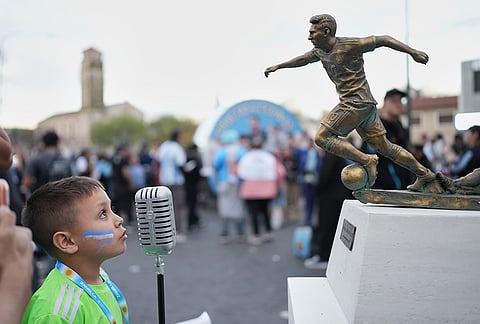 A child looks at the statue of Argentina's Lionel Messi before an international friendly soccer match against Benin, marking his farewell appearance for the national team, in Buenos Aires, Argentina, Tuesday, Oct.6, 2026. 