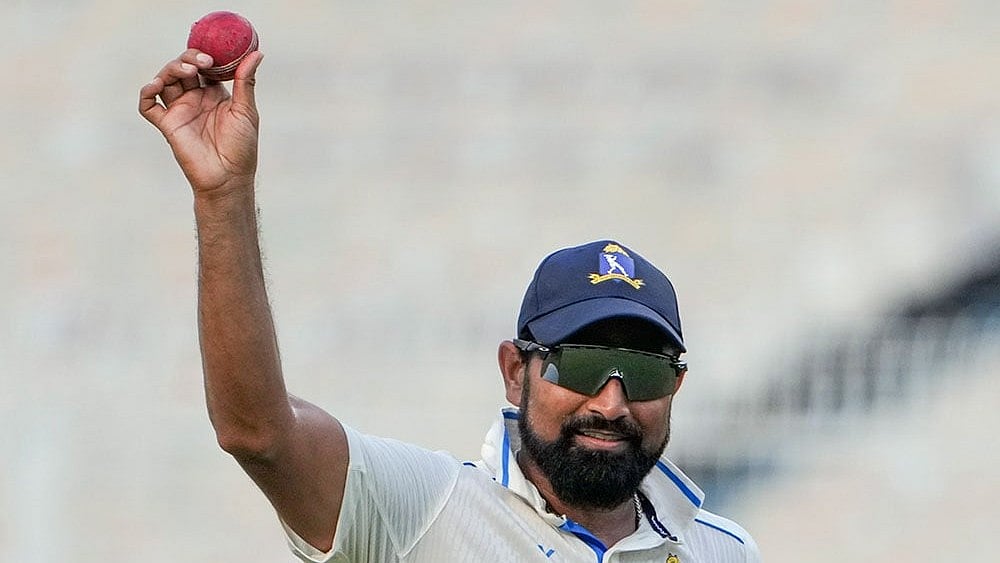Bengal pacer Mohammed Shami holds up the ball in celebration after claiming a five-wicket haul on the fourth day of the Ranji Trophy match against Gujarat, at Eden Gardens, Kolkata. - Photo: PTI/Swapan Mahapatra