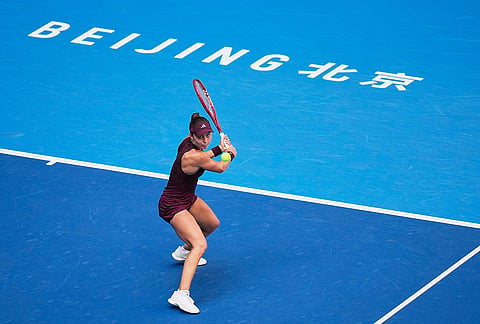 Iva Jovic of the United States, returns a ball to Iga Swiatek of Poland during the fourth round of the women's singles match at the China Open tennis tournament in Beijing, Wednesday, Oct. 7, 2026. 
