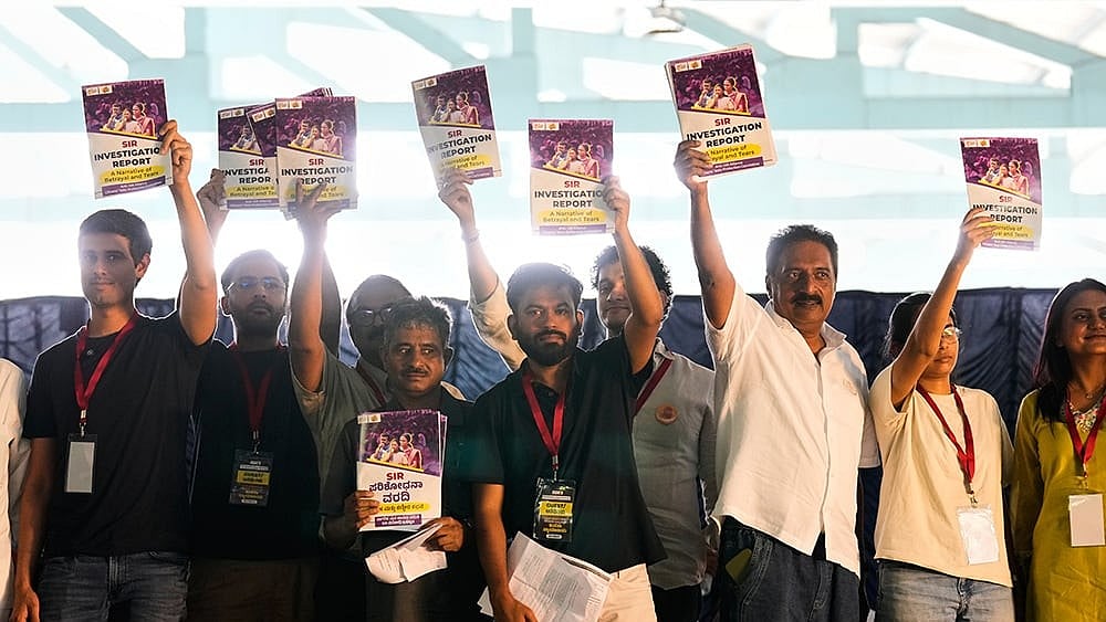 Indian influencer and activist Dhruv Rathee, left, Cockroach Janta Party founder Abhijeet Dipke, fifth left, Indian actor Prakash Raj, seventh left, and other supporters carry copies of a report on Special Intensive Revision (SIR), which removed a large number of Indian voters from the electoral roll, during a protest demanding the resignation of the country's election chief Gyanesh Kumar, in Bengaluru, India, Thursday, Oct. 8, 2026.  - | Photo: AP/Aijaz Rahi