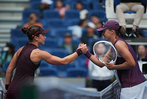 Iga Swiatek of Poland, right, is congratulated by Iva Jovic of the United States, left, during the fourth round of the women's singles match at the China Open tennis tournament in Beijing, Wednesday, Oct. 7, 2026. 