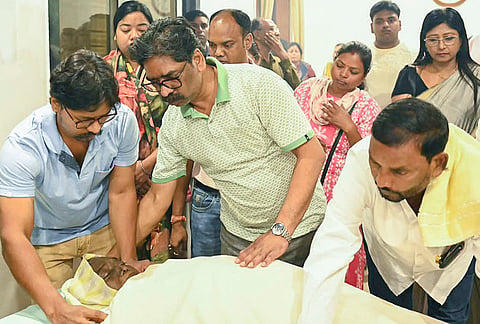 Jharkhand Chief Minister Hemant Soren stands beside the mortal remains of his late mother Rupi Soren as family members and relatives gather to pay their final respects at the Chief Minister's official residence in Morabadi, Ranchi. Rupi Soren, wife of late JMM founder Shibu Soren, passed away on Wednesday evening at the age of 80 after a prolonged illness. 