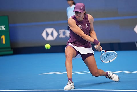 Iga Swiatek of Poland returns a ball to Iva Jovic of the United States during the fourth round of the women's singles match at the China Open tennis tournament in Beijing, Wednesday, Oct. 7, 2026. 
