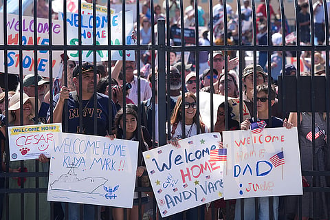 Family and friends await the USS Abraham Lincoln aircraft carrier's return to Naval Air Station North Island after deployment Thursday, Oct. 8, 2026, in Coronado, Calif.