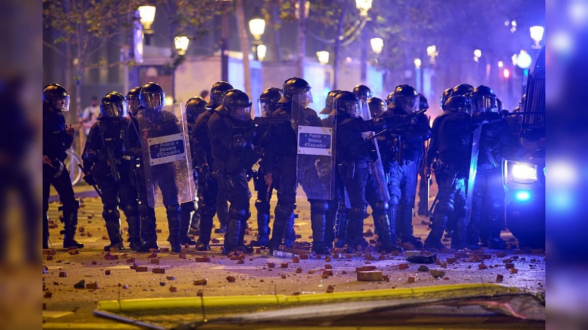 Riot police are pelted with rocks by protesters during clashes following a demonstration over Spain's housing crisis, hours after Prime Minister Pedro Sánchez announced an early general election, in Barcelona - AP Photo/Emilio Morenatti
