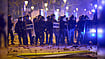 AP Photo/Emilio Morenatti : Riot police are pelted with rocks by protesters during clashes following a demonstration over Spain's housing crisis, hours after Prime Minister Pedro Sánchez announced an early general election, in Barcelona