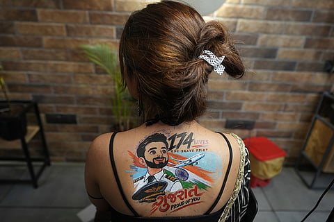 An Indian woman shows a temporary tattoo, depicting Indian FlyDubai pilot Smit Machchhar, on her back ahead of Navratri, a nine night Hindu festival, in Ahmedabad, India, Thursday, Oct. 8, 2026.