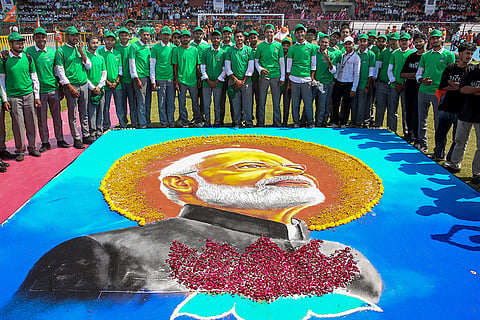 Students pose for a photograph around a giant rangoli portrait of Prime Minister Narendra Modi during the 'Seva Ke Rang Rashtra Ke Sang' event to commemorate his 25 years in public service, in Bhopal, Madhya Pradesh.