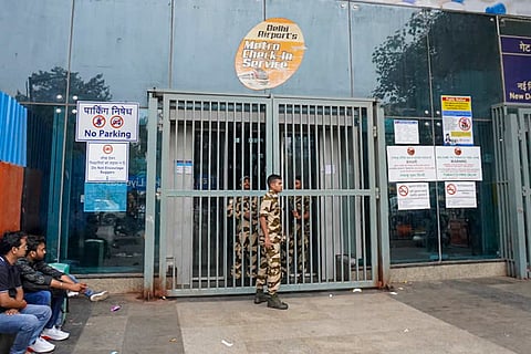 Security personnel stand guard outside the closed entry gates of New Delhi Metro station as heavy police deployment and entry restrictions are enforced ahead of a planned protest by Cockroach Janta Party (CJP) members, in New Delhi, Saturday, Oct. 10, 2026.