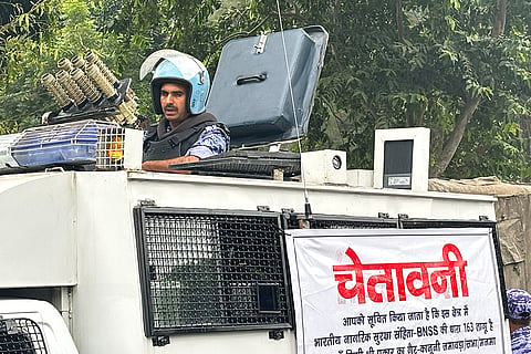 An armored vehicle with a banner warning citizens against unlawful gathering stands near the venue of a youth protest demanding the resignation of the country's election chief Gyanesh Kumar, in New Delhi, India, Saturday, Oct. 10, 2026.