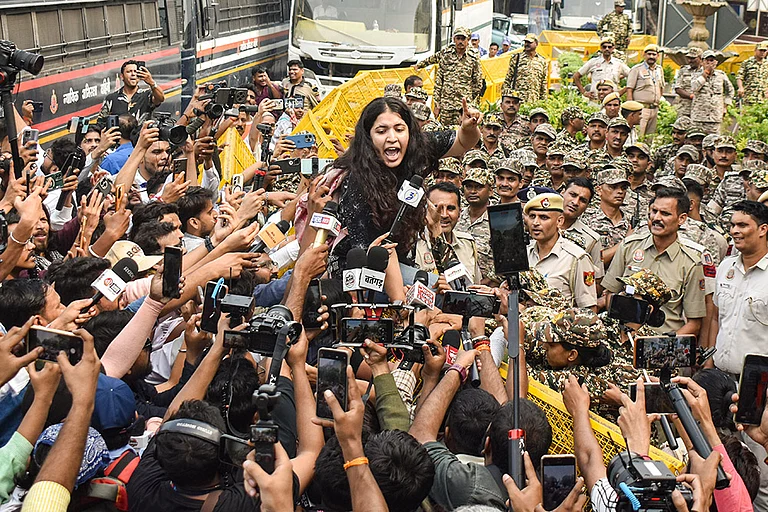 A demonstrator addresses media persons during a protest organised by the Cockroach Janta Party (CJP) demanding the resignation of Chief Election Commissioner (CEC) Gyanesh Kumar over alleged electoral roll irregularities, at Connaught Place, in New Delhi. - | Photo: PTI/Rushikesh More