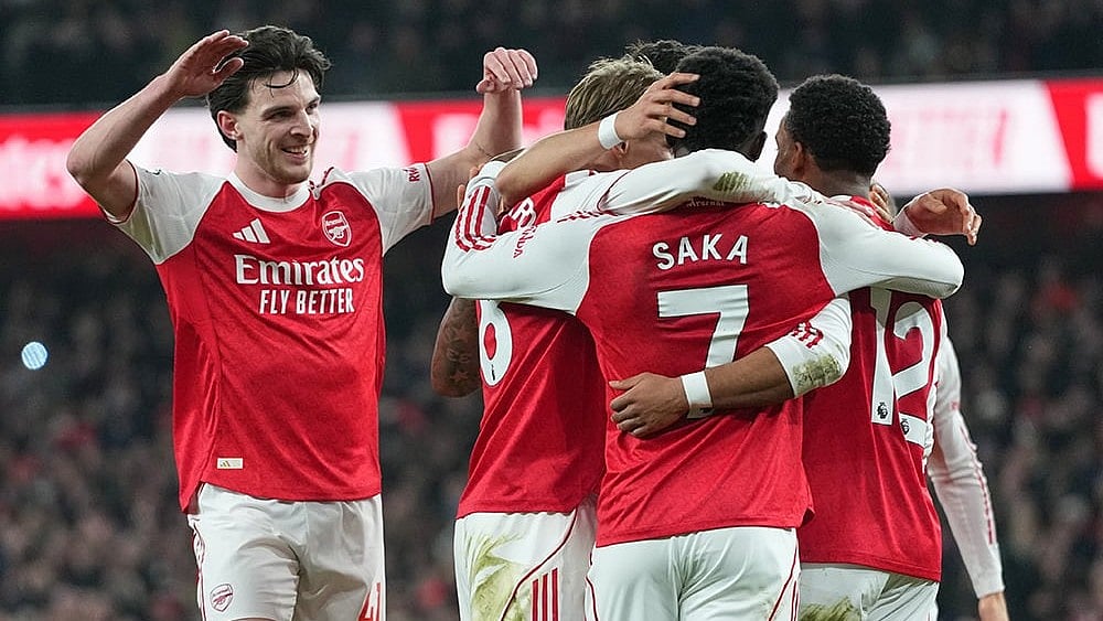 Arsenal players celebrate after Manchester United's Lisandro Martinez scored an own goal during the English Premier League soccer match between Arsenal and Manchester United in London. - | Photo: AP/Kirsty Wigglesworth