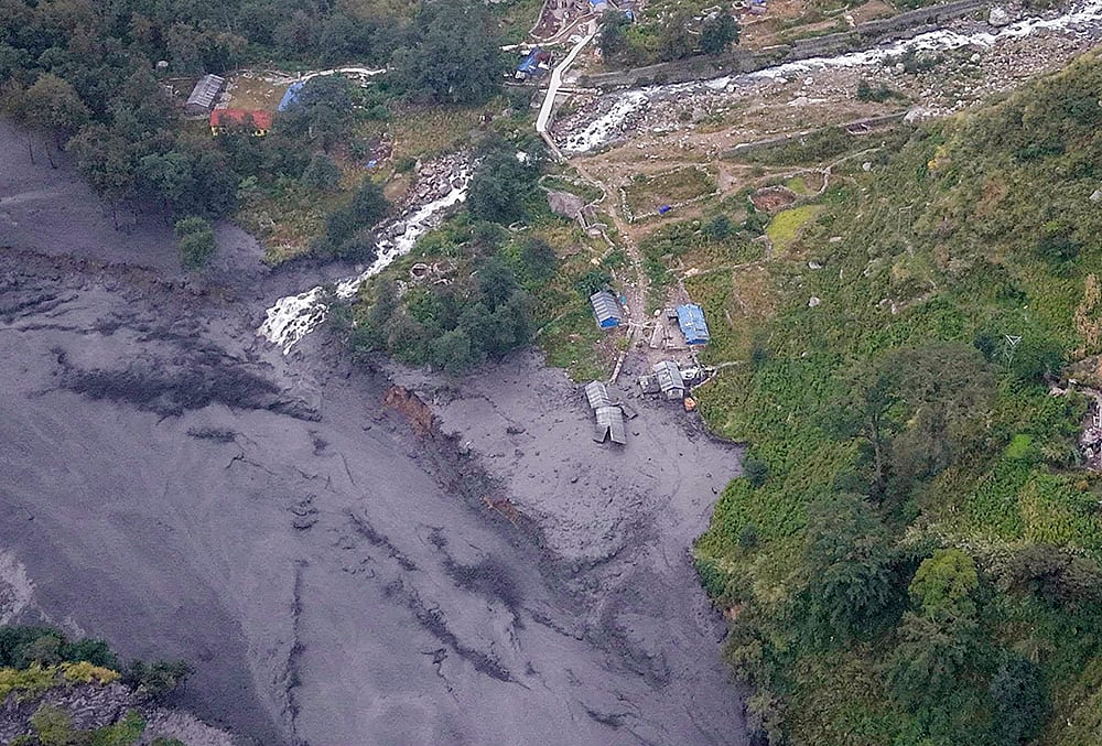 An aerial view shows mudslide debris and floodwaters overflowing the Budhi Gandaki river following a sudden flash flood triggered by a suspected landslide in the Chekampar area, in Gorkha district, Nepal, Sunday, Oct. 11, 2026. Preliminary reports indicate that around 35 houses and several bridges were swept away in the disaster. No casualties have been reported so far, according to the National Disaster Risk Reduction and Management Authority (NDRRMA). 
 - |Photo: PTI/Abhishek Maharjan