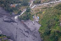In Photos: Nepal Flash Flood Sweeps Away Around 35 Houses, Several Bridges |Photo: PTI/Abhishek Maharjan : An aerial view shows mudslide debris and floodwaters overflowing the Budhi Gandaki river following a sudden flash flood triggered by a suspected landslide in the Chekampar area, in Gorkha district, Nepal, Sunday, Oct. 11, 2026. Preliminary reports indicate that around 35 houses and several bridges were swept away in the disaster. No casualties have been reported so far, according to the National Disaster Risk Reduction and Management Authority (NDRRMA).