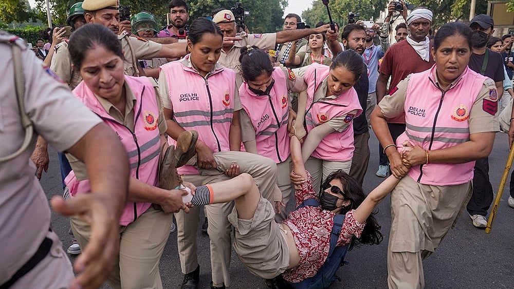 Police personnel detain a woman activist during a demonstration call by the Cockroach Janta Party (CJP)  - | Photo: PTI/Karma Bhutia
