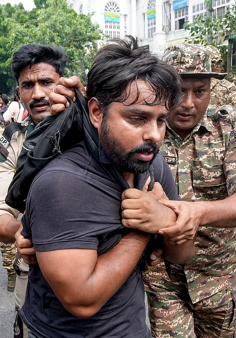 Police personnel detain protestors amid continued demonstration calls by the Cockroach Janta Party (CJP) demanding the resignation of Chief Election Commissioner (CEC) Gyanesh Kumar, in Connaught Place area, New Delhi, Sunday, Oct. 11, 2026. 
