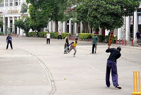 Youngsters play cricket on the deserted streets of the Inner Circle in Connaught Place as commercial establishments remain closed and traffic movement restricted during security restrictions and protest calls by Cockroach Janta Party (CJP), in New Delhi.