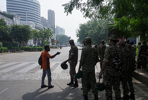 A commuter speaks with security personnel standing guard along a deserted road at Connaught Place, ahead of a protest call by Cockroach Janta Party (CJP) against Chief Election Commissioner (CEC) Gyanesh Kumar over alleged electoral roll irregularities, in New Delhi, Saturday, Oct. 10, 2026. 
