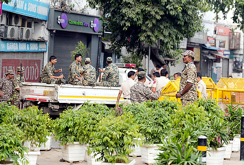 Security personnel stand guard and place barricades along the Outer Circle of Connaught Place to restrict vehicular and pedestrian movement following continued demonstration calls by the Cockroach Janta Party (CJP) demanding the resignation of Chief Election Commissioner (CEC) Gyanesh Kumar, in New Delhi, Sunday, Oct. 11, 2026. 