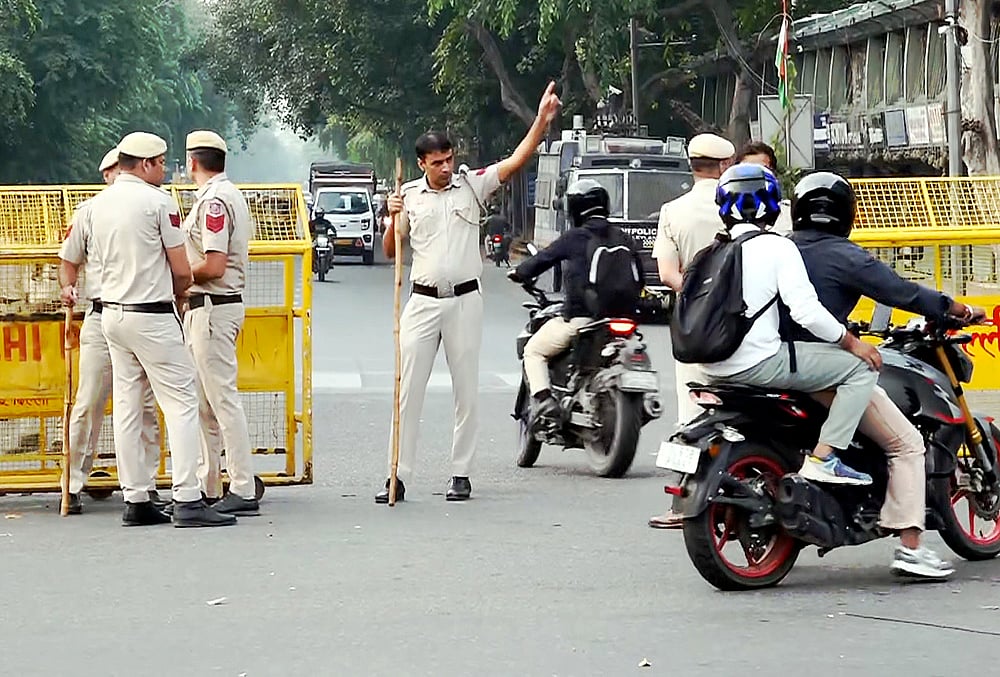 Security personnel stand guard and place barricades along the Outer Circle of Connaught Place to restrict vehicular and pedestrian movement following continued demonstration calls by the Cockroach Janta Party (CJP) demanding the resignation of Chief Election Commissioner (CEC) Gyanesh Kumar, in New Delhi, Sunday, Oct. 11, 2026. 
