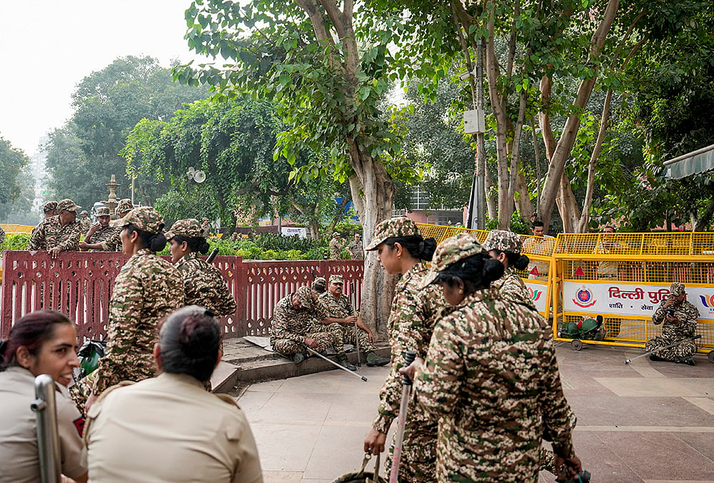 Security personnel stand guard and place barricades along the Outer Circle of Connaught Place to restrict vehicular and pedestrian movement following continued demonstration calls by the Cockroach Janta Party (CJP) demanding the resignation of Chief Election Commissioner (CEC) Gyanesh Kumar, in New Delhi, Sunday, Oct. 11, 2026. 
