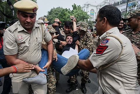 Security personnel detain a protester during a youth demonstration demanding the resignation of the country's election chief Gyanesh Kumar, in New Delhi, Sunday, Oct. 11, 2026. 
