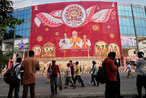 Commuters throng along the road in front of the Eden Gardens cricket stadium decorated ahead of Durga Puja festival, in Kolkata, India, Saturday, Oct. 10, 2026. 
