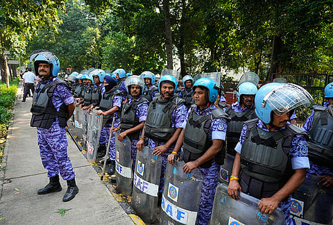 Security personnel watch as workers of India's opposition Congress party gather for a march toward the Supreme Court demanding the resignation of Chief Election Commissioner Gyanesh Kumar in New Delhi, India, Monday, Oct. 12, 2026. 
