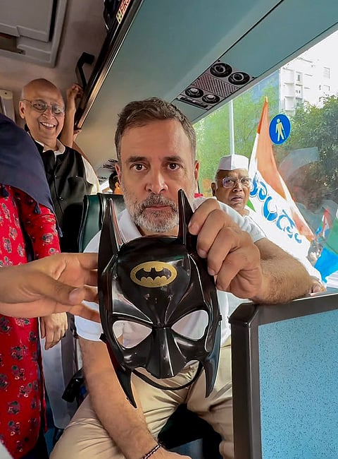 In this image posted on Oct. 12, 2026, Congress leader Rahul Gandhi shows a comic-hero batman's mask  during ‘March for Democracy’ by INDIA bloc leaders, as they proceed towards the Supreme Court, to file a petition against Chief Election Commissioner (CEC) Gyanesh Kumar and 'vote chori', in New Delhi.