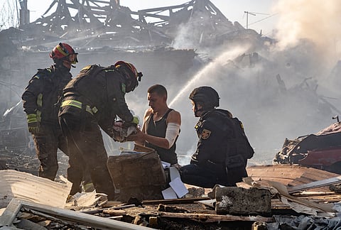 An injured man collects his personal belongings in front of his house destroyed in a Russian strike on Kharkiv, Ukraine, Sunday, Oct. 11, 2026. 