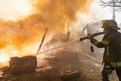 A rescue worker puts out a fire at residential houses destroyed in a Russian strike on Kharkiv, Ukraine, Sunday, Oct. 11, 2026. 
