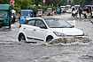 | Photo: PTI  : Commuters make their way through a waterlogged road after heavy rain, in Noida.