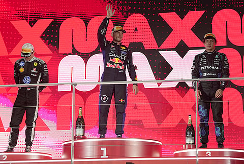 Red Bull driver Max Verstappen, center, of the Netherlands celebrates flanked with Mercedes driver Andrea Kimi Antonelli of Italy and Ferrari driver Charles Leclerc of Monaco after winning the Singapore Formula One Grand Prix race in Singapore, Sunday, Oct. 11, 2026. 
