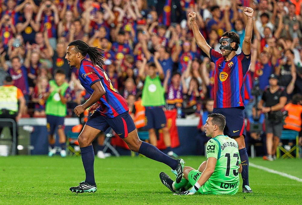 Barcelona's Jules Kounde, left, and Barcelona's Eric Garcia, right, celebrate after scoring during the Spanish La Liga soccer match between Barcelona and Getafe in Barcelona, Spain, Saturday, Oct. 10, 2026.  - | Photo: AP/Joan Monfort