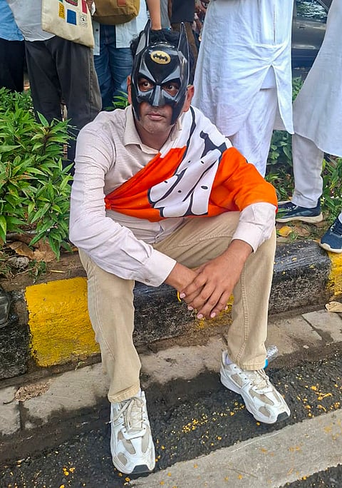 A Congress worker wearing a batman mask during a protest march by INDIA bloc leaders towards Supreme Court, to file a petition against Chief Election Commissioner Gyanesh Kumar and 'vote chori', in New Delhi, Monday, Oct. 12, 2026. 