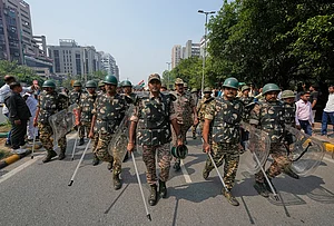 | Photo: AP/Manish Swarup : Security personnel escort workers of India's opposition Congress party as they gather for a march toward the Supreme Court demanding the resignation of Chief Election Commissioner Gyanesh Kumar in New Delhi, India, Monday, Oct. 12, 2026.