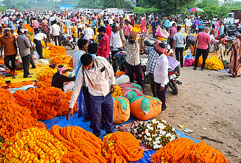 People shop for floral garlands during the ‘Navratri’ festival, in Prayagraj.
