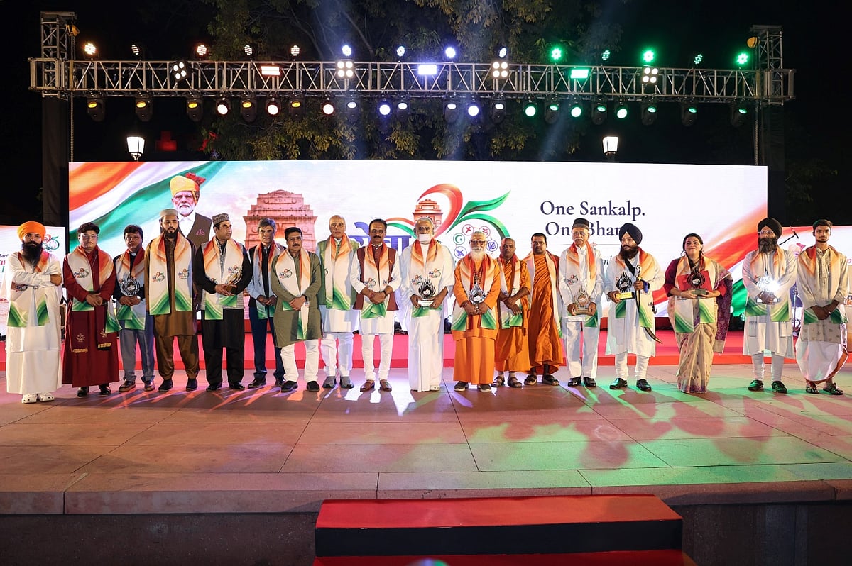 Dignitaries holding awards on stage at an event with One Sankalp tagline banner