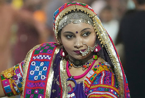 A woman in traditional attire performs Gujarat state's folk dance called Garba during the celebration of nine nights Hindu festival Navratri, in Ahmedabad, Monday, Oct. 12, 2026. 