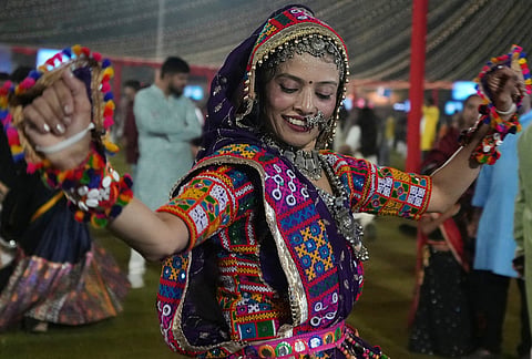 A woman in traditional attire performs Gujarat state's folk dance called Garba during the celebration of nine nights Hindu festival Navratri, in Ahmedabad, Monday, Oct. 12, 2026. 