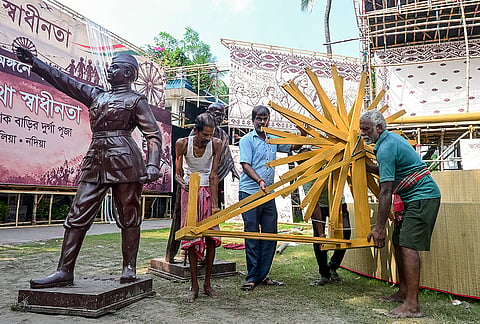 Artisans install a 'Charkha' at a Durga Puja pandal themed on India's independence movement, in Nadia, West Bengal, Monday, Oct. 12, 2026. 
