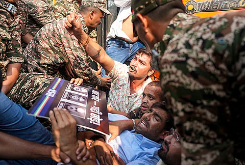 Security personnel detain National Students' Union of India (NSUI) activists during a protest demanding immediate resignation of Chief Election Commissioner (CEC) Gyanesh Kumar, at Connaught Place, in New Delhi, Tuesday, Oct. 13, 2026. 
