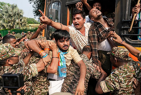 Security personnel detain National Students' Union of India (NSUI) activists during a protest demanding immediate resignation of Chief Election Commissioner (CEC) Gyanesh Kumar, at Connaught Place, in New Delhi, Tuesday, Oct. 13, 2026. 
