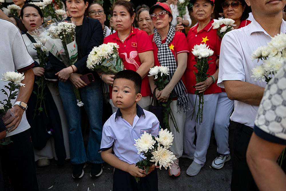 People watch as 731 sets of martyrs' remains found at Le Thi Rieng Cultural Park are transferred for burial at Ho Chi Minh City Martyrs' Cemetery Wednesday, Oct. 14, 2026, in Ho Chi Minh City, Vietnam. - | Photo: AP/Thanh Hue